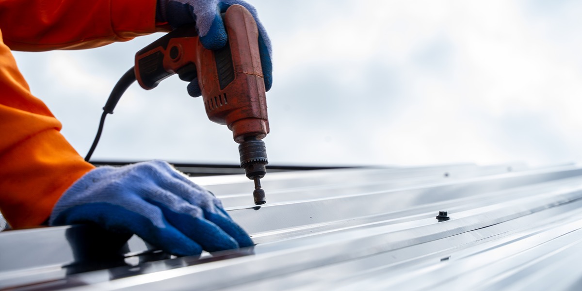 screwing fastener into metal roof